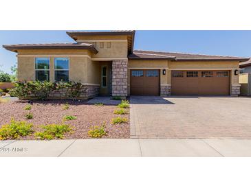 Charming single-story home showcasing a well-manicured lawn and inviting three-car garage at 20603 W Alsap Rd, Buckeye, AZ 85396