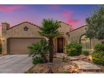 Charming home featuring a stucco exterior, clay tile roof, desert landscaping, and mature palm trees at 27088 W Sequoia Dr, Buckeye, AZ 85396