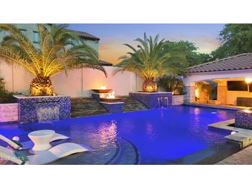 Stunning outdoor pool featuring palm trees, fire bowls, waterfalls, a swim up bar and comfortable lounge chairs at 2985 N Point Ridge Rd, Buckeye, AZ 85396