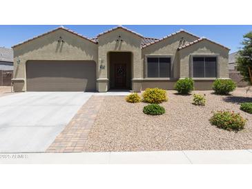 Charming single-story home featuring a well-manicured, low maintenance front yard and a two-car garage at 30776 W Earll Dr, Buckeye, AZ 85396