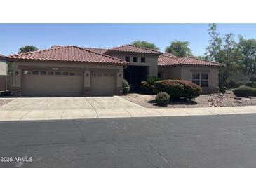 Charming home with a two-car garage, desert landscaping and a red tile roof at 4581 E Apricot Ln, Gilbert, AZ 85298