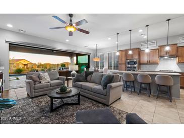 Spacious living room with modern furnishings that seamlessly connect to the gourmet kitchen and outdoor spaces at 8633 E Kael Cir, Mesa, AZ 85207