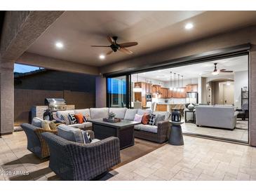 Relaxing covered patio with comfortable seating, an outdoor kitchen area, and seamless indoor-outdoor living at 8633 E Kael Cir, Mesa, AZ 85207