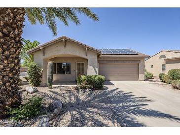 Charming single-story home featuring desert landscaping, solar panels, and a two-car garage at 16186 W Port Royale Ln, Surprise, AZ 85379