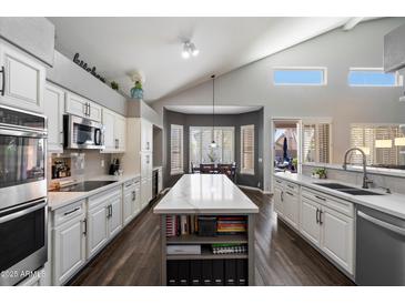 Bright kitchen with a large island, white cabinetry, modern appliances, and gray backsplash at 4569 E Lariat Ln, Phoenix, AZ 85050