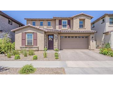 Charming two-story home featuring a tile roof and a welcoming front yard with desert landscaping at 4607 S Venus --, Mesa, AZ 85212