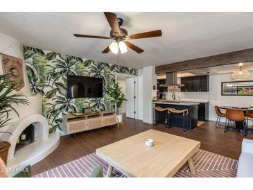 Inviting living room featuring a charming fireplace, hardwood floors, and open layout to the modern kitchen at 7557 N Dreamy Draw Dr # 139, Phoenix, AZ 85020