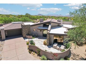 Stunning desert home showcasing custom stone, modern architecture and a serene outdoor patio with mountain views at 10651 E Fernwood Ln, Scottsdale, AZ 85262