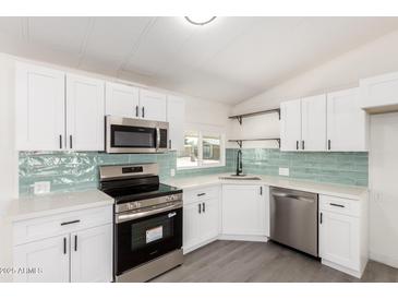 Bright kitchen features white cabinetry, stainless steel appliances, and a stylish subway tile backsplash at 11000 N 91St Ave # 20, Peoria, AZ 85345