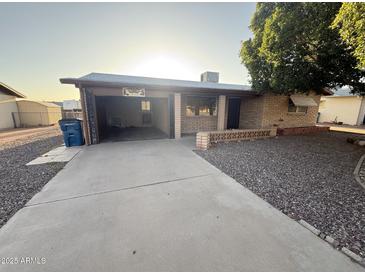 Charming single-story brick home featuring a driveway and open garage at 1428 S Palo Verde Dr, Apache Junction, AZ 85120