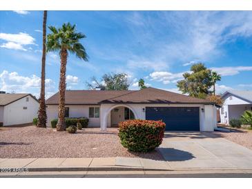 Charming single-story home featuring mature palm trees, a two-car garage, and a well-maintained yard at 1800 W Shawnee Dr, Chandler, AZ 85224