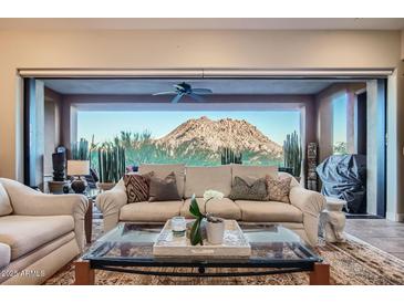 Living room featuring a comfortable sofa, mountain views, and natural light from the large windows at 27000 N Alma School Pkwy # 1033, Scottsdale, AZ 85262