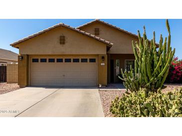 Tan home with a desert landscape including cactus and flowering bushes and a two car garage at 3742 E Sandy Way, Gilbert, AZ 85297