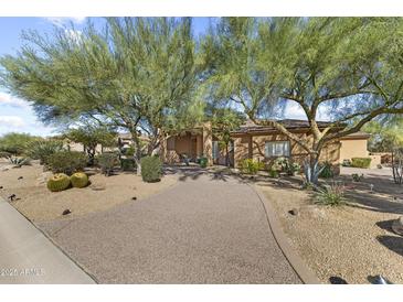 Beautiful home featuring desert landscaping, a private driveway and mature trees in a bright, sunny setting at 7335 E Quail Track Rd, Scottsdale, AZ 85266