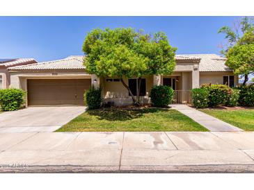 Charming single-story home with a well-manicured lawn, mature landscaping, and a two-car garage at 9002 W Caribbean Ln, Peoria, AZ 85381