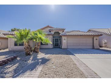 Charming single-story home featuring desert landscaping, a two-car garage, and covered entry at 15360 N 87Th Ave, Peoria, AZ 85381
