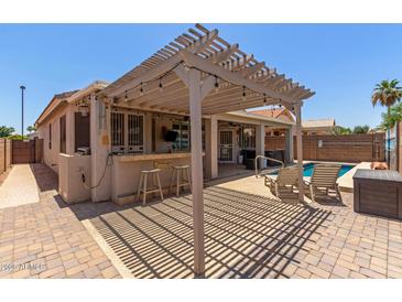 Beautiful backyard with a bar, pergola and plenty of room for entertaining at 18080 W Spencer Dr, Surprise, AZ 85374