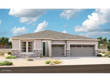 Charming single-story home featuring a three-car garage and decorative stone accents at 27611 N 176Th Dr, Surprise, AZ 85387