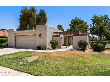 Charming single-story home featuring a well-maintained lawn, desert landscaping, and an attached two-car garage at 347 Leisure World --, Mesa, AZ 85206
