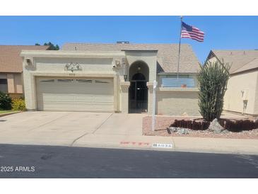 Charming single-story home with a two-car garage, landscaped front yard, and American flag at 6036 W Mescal St, Glendale, AZ 85304