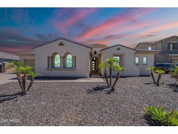 Charming single-story home with desert landscaping, arched windows, and elegant architectural details at 9345 W Robin Ln, Peoria, AZ 85383