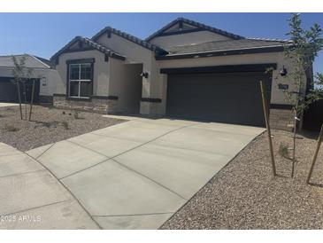 Charming single-story home featuring a stone facade, neutral colors, and a spacious two-car garage at 17738 W Onyx Ave, Waddell, AZ 85355