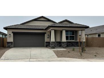 Charming single-story home featuring neutral stucco, a two-car garage, and stone accents for a modern curb appeal at 22580 N Lynn St, Maricopa, AZ 85138