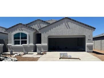 Newly built single-story home featuring gray stucco, a wide garage, and a picture window, awaiting final touches at 25478 W Graham Trl, Buckeye, AZ 85326