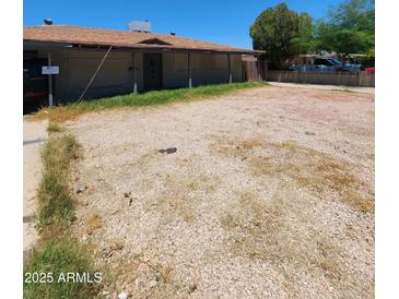 Exterior shot of property featuring gravel yard, covered front porch and flat roof at 3308 W Missouri Ave, Phoenix, AZ 85017