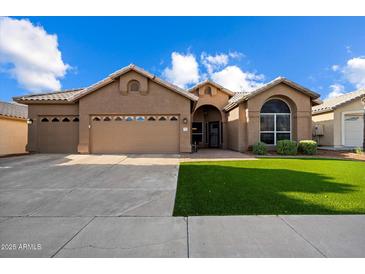 Charming single-story home with a well-manicured lawn and a three-car garage at 3350 E Rosemonte Dr, Phoenix, AZ 85050