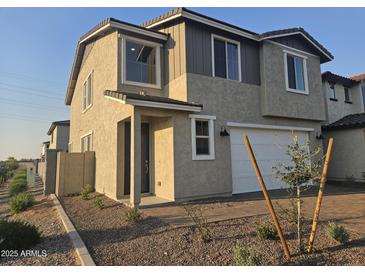 Two-story home boasts neutral stucco, dark trim, a two-car garage and desert landscaping at 3372 S 180Th Ln, Goodyear, AZ 85338