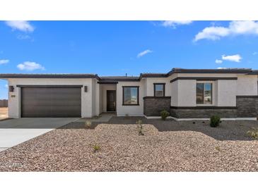 Charming single-story home with desert landscaping, stone accents, and attached two-car garage at 37735 W Santa Maria St, Maricopa, AZ 85138