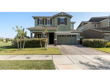 Charming two-story home featuring a brick driveway, attached two car garage, and lush green lawn at 3818 E Appaloosa Rd, Gilbert, AZ 85296