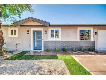 Charming home exterior boasting a blue front door, stone accents, and well-manicured artificial lawn at 5236 S 19Th Ave, Phoenix, AZ 85041