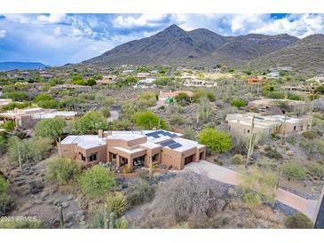 Desert home featuring sleek architectural design with a three-car garage and beautiful desert landscaping at 5892 E Carefree Mountain Dr, Carefree, AZ 85377