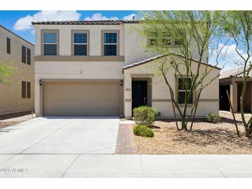 Charming two-story home featuring a front yard, a two-car garage and a welcoming entrance at 12531 W Glenn Dr, Glendale, AZ 85307
