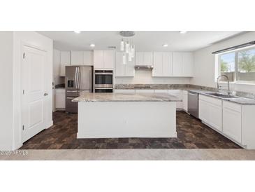 Stylish kitchen features white cabinetry, stainless steel appliances, and a granite countertop island at 12531 W Glenn Dr, Glendale, AZ 85307