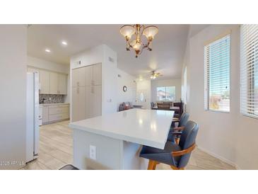 Bright kitchen with a center island, pendant lighting, and a seamless flow into the adjacent dining and living areas at 16537 N Oachs Dr, Surprise, AZ 85374