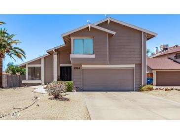 Charming two-story home featuring desert landscaping, a two-car garage and freshly painted facade at 1914 S Brooks Cir, Mesa, AZ 85202