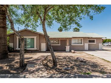 Charming single-story home with a mature tree and well-maintained front yard on a sunny day at 6334 N 37Th Ave, Phoenix, AZ 85019