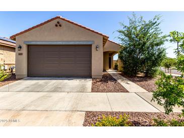 Charming single-level home showcasing a neutral-toned exterior with desert landscaping and a two-car garage at 14233 W Georgia Dr, Surprise, AZ 85379