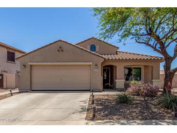 Charming single-story home featuring a two-car garage, tile roof, and a well-manicured front yard with desert landscaping at 16219 W Yucatan Dr, Surprise, AZ 85379