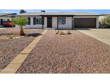 Charming single-story home with desert landscaping, brick walkway, and a dark-colored attached garage at 2127 W Marco Polo Rd, Phoenix, AZ 85027