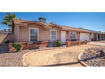 Charming single-story home featuring a well-maintained exterior with a brick accent wall and desert landscaping at 307 W Piute Ave, Phoenix, AZ 85027