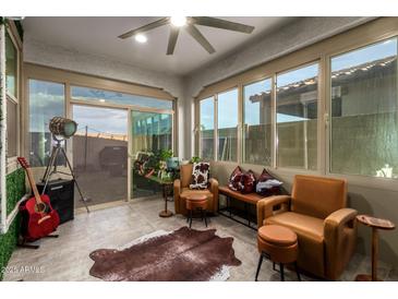Bright sunroom featuring tile floors, ceiling fan, and lots of windows at 5897 N 195Th Dr, Litchfield Park, AZ 85340