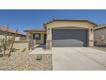 Charming single-story home featuring a stone-accented facade, two-car garage and low maintenance landscaping at 16762 W Alameda Rd, Surprise, AZ 85387