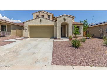 Charming two-story home showcasing a beige stucco facade, a spacious garage, and a well-maintained, desert-style landscaped yard at 19022 W Shangri La Rd, Surprise, AZ 85388