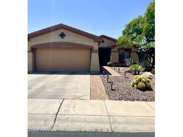 Charming single-story home featuring a two-car garage and desert landscaping with mature trees at 2461 W Muirfield Dr, Anthem, AZ 85086
