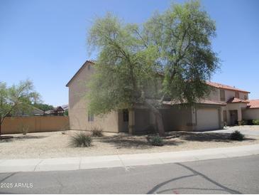 Two-story home featuring a well-kept yard with mature trees providing shade at 40504 N Las Praderas St, San Tan Valley, AZ 85140