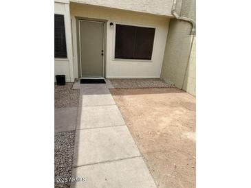 Inviting front entrance with a well-maintained walkway leading to the front door and a minimalist landscape at 5975 N 48Th Dr, Glendale, AZ 85301